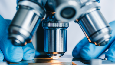 A Researcher using microscope for clinical trials