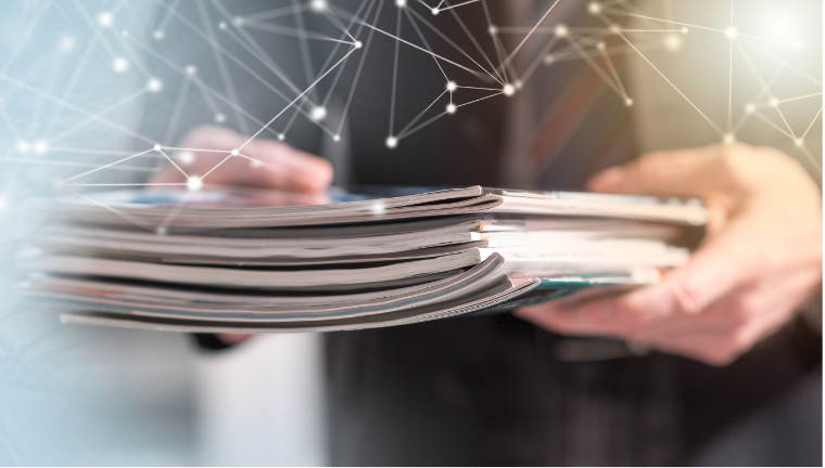 A healthcare professional holding a pile of latest scientific publications